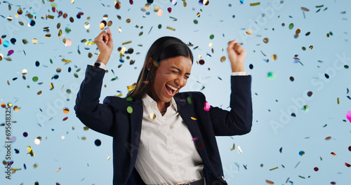 Happy business woman, confetti and celebration for winning or promotion against a blue studio background. Excited female person or employee smile in freedom for victory, achievement or party event