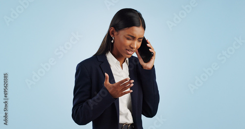 Business, phone call and woman with stress, angry and employee isolated on a blue studio background. Mockup space, person and entrepreneur with a smartphone, connection and frustrated with emotions photo