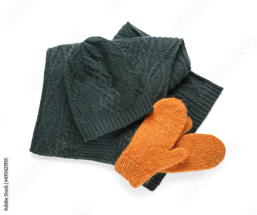 Pair of orange knitted mittens with warm hat and scarf on white background