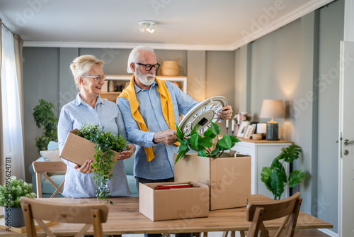 Senior couple man and woman husband wife pack or unpack boxes moving photo
