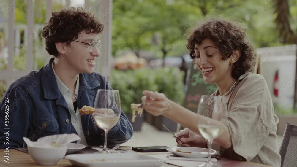 Couple of women eating and having fun during pleasant lunch in an open-air restaurant. Cinematic 4k. Couple of women eating and having fun during pleasant lunch in an open-air restaurant. Cinematic 4k.