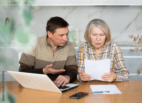 Man and woman are outraged by the increase in utility bills, checking the data on the management company website