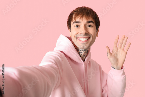 Smiling young man in pink h...