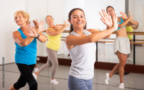 Dancing latin american woman, engaged in a group class in the studio, practices an energetic swing