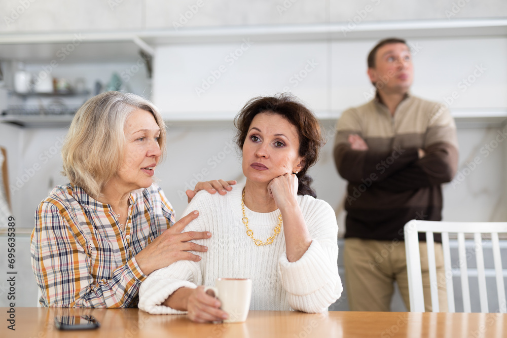 Family quarrel, old woman calming woman, all are upset and dissatisfied