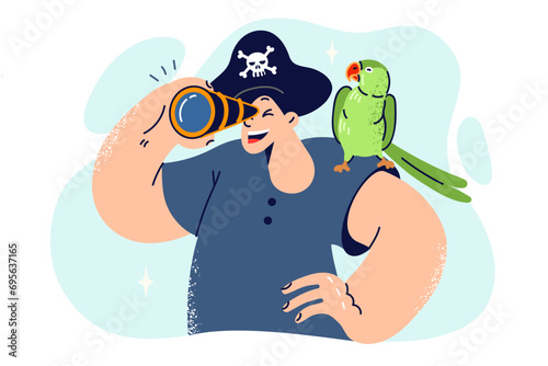 Little boy in pirate hat looks through spyglass and holds parrot on shoulder, dreaming of sea voyage