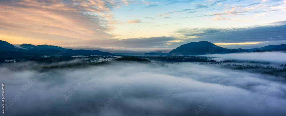 Valley by Mountains and Green Trees covered in fog. Canadian Landscape Nature Aerial Background