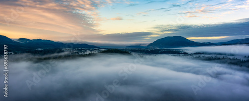 Valley by Mountains and Green Trees covered in fog. Canadian Landscape Nature Aerial Background