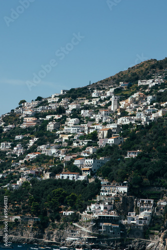 Amalfi Sea Coast with Umbrellas, people swim, and Yachts. Clean and blue sea where to swim. Photo for tourism and summer background. Concept of vacation and beach life in the open air colorful