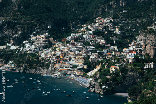 Amalfi Sea Coast with Umbrellas, people swim, and Yachts. Clean and blue sea where to swim. Photo for tourism and summer background. Concept of vacation and beach life in the open air colorful