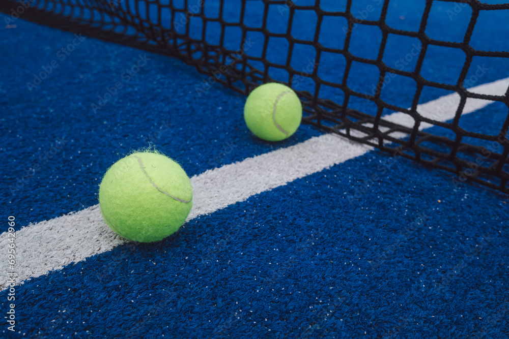 two balls in a blue paddle tennis court, racket sports courts