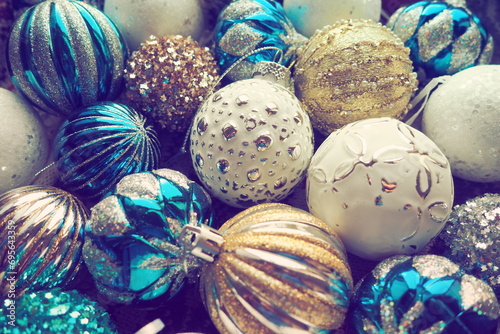 New Year's Christmas balls and decorations close up. A lot of decoration of golden, blue, yellow, white, silver. Striped Christmas balls lie on surface. Festive beautiful colorful background. Design.