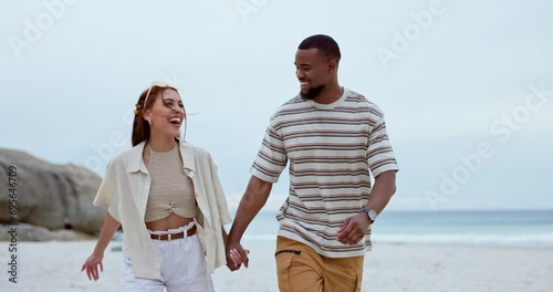 Couple, talking and holding hands while walking at beach for love, summer holiday and vacation for travel to Bali. Happy man, interracial woman and laugh at ocean for funny chat, support and freedom