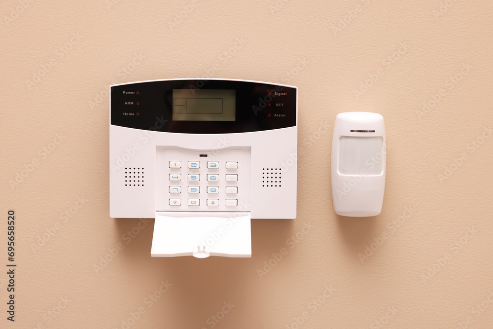 Home security alarm system on beige wall - obrazy, fototapety, plakaty 