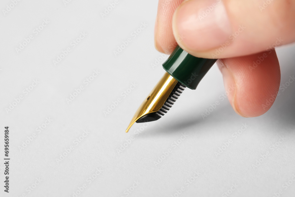 Woman with fountain pen above white paper, closeup. Space for text Woman with fountain pen above white paper, closeup. Space for text