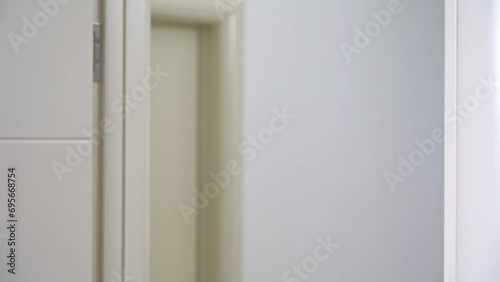 Man standing in doorway thinks about troubling matters recalling new details and exhales with smile of relief. Man heaves sigh of relief near room door