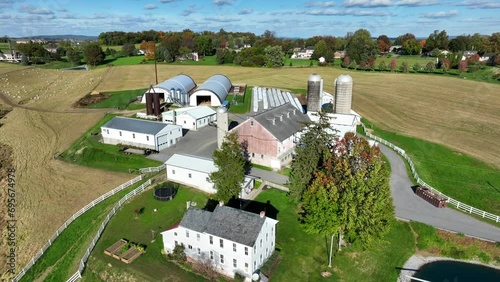 Pennsylvania farm in autumn: white farmhouse, barns, silos, and harvested fields. Aerial. photo