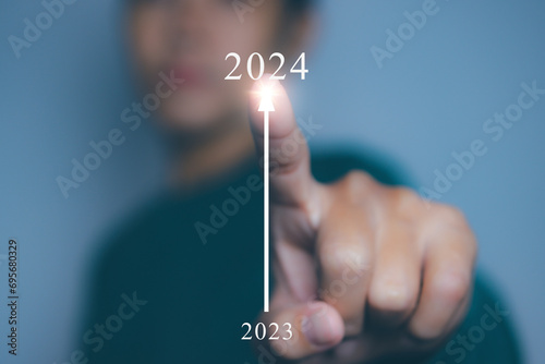 Young man pointing target in 2024. Progress growing potential success new business. photo