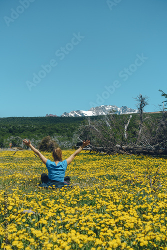 woman feeling the freedom of being in nature in a field of yellow flowers