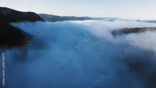 Thick morning fog engulfs the wide valley. Aerial view fast forward motion. photo