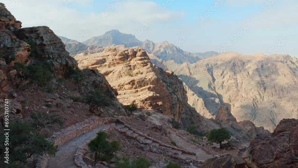 Panning shot of a rocky canyon with a stone stairway in Petra Jordan Panning shot of a rocky canyon with a stone stairway in Petra Jordan