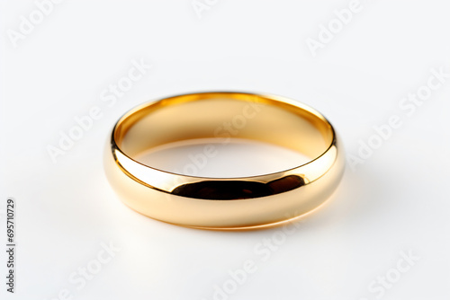 a gold wedding ring on a white surface