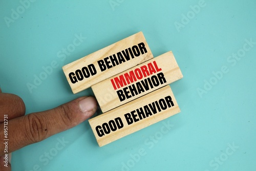 wood with the words good behavior and immoral behavior. the concept of behavior or ethics. the word immoral behavior is rejected photo