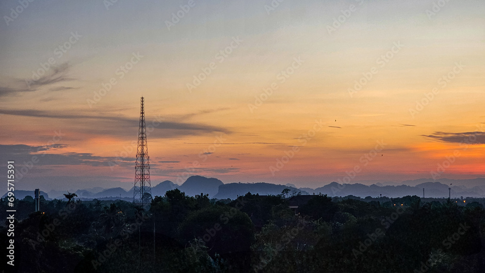 Silhouettes of the electric power masts and cables, Pylons against sunset over countryside. The sunset and electrical network. High-voltage power lines at sunset. Electricity distribution station.