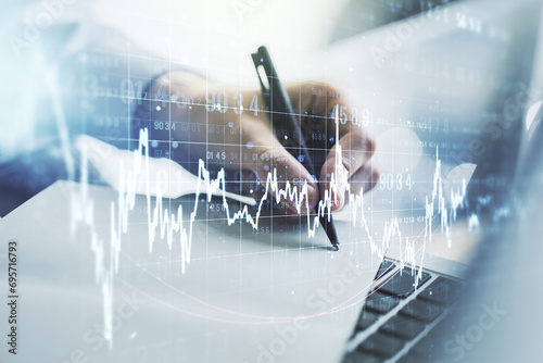 Multi exposure of abstract financial graph with hand writing in notebook on background, financial and trading concept