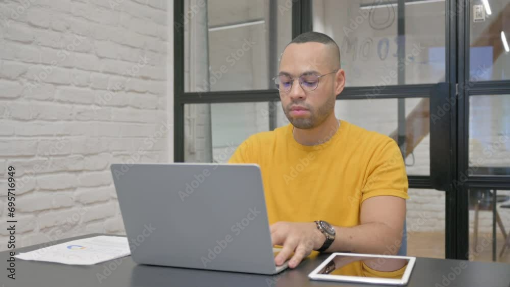 Hispanic Man Working on Laptop in Office Hispanic Man Working on Laptop in Office
