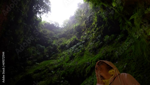 Woman smiling for visiting the interior of Algar do Carvao lava tunnel. Low angle photo