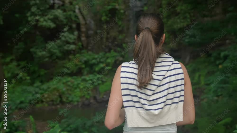 model girl looking at a waterfall in the jungle in Madeira Portugall , deep in the green forest. model girl looking at a waterfall in the jungle in Madeira Portugall , deep in the green forest.