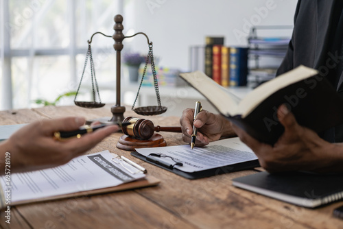 Lawyer holds a pen and provides consulting services in business disputes with a scale and hammer. In the event that the customer is defrauded Close-up pictures photo