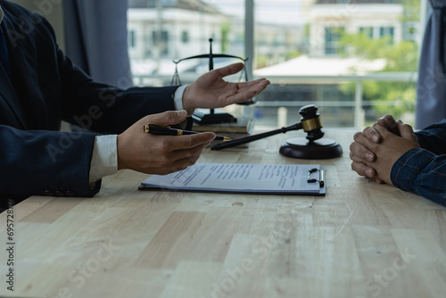 Lawyer holds a pen and provides consulting services in business disputes with a scale and hammer. In the event that the customer is defrauded Close-up pictures