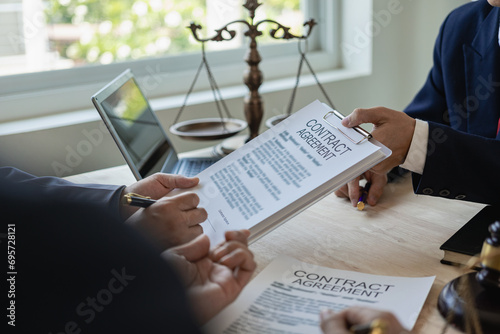 Lawyer holds a pen and provides consulting services in business disputes with a scale and hammer. In the event that the customer is defrauded Close-up pictures photo