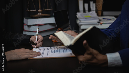 Lawyer holds a pen and provides consulting services in business disputes with a scale and hammer. In the event that the customer is defrauded Close-up pictures photo