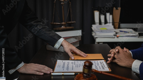 Lawyer holds a pen and provides consulting services in business disputes with a scale and hammer. In the event that the customer is defrauded Close-up pictures