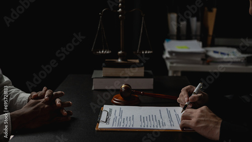 Lawyer holds a pen and provides consulting services in business disputes with a scale and hammer. In the event that the customer is defrauded Close-up pictures