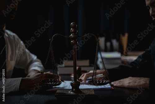 Lawyer holds a pen and provides consulting services in business disputes with a scale and hammer. In the event that the customer is defrauded Close-up pictures