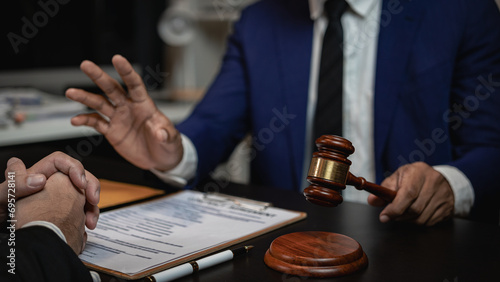 Lawyer holds a pen and provides consulting services in business disputes with a scale and hammer. In the event that the customer is defrauded Close-up pictures