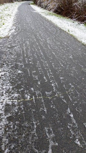 Car tracks on snowy road frozen ground