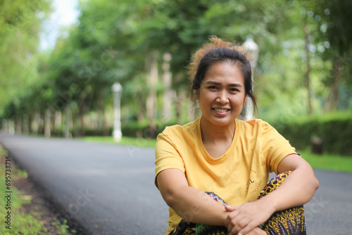 Beautiful smiling Asian woman in the park green trees in spring nature background