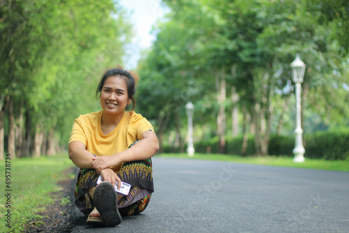 Beautiful smiling Asian woman in the park green trees in spring nature background