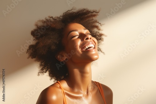 A woman with an afro hairstyle smiling and looking upwards. Suitable for promoting diversity, beauty, and happiness