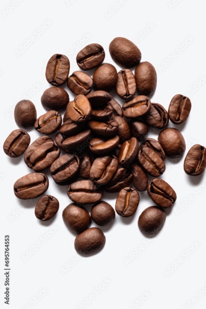 Naklejka premium A pile of coffee beans on a white surface. Suitable for coffee shop advertisements and coffee-related blog posts