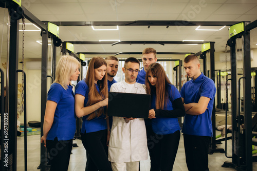 group of doctors physiotherapists looking at laptop