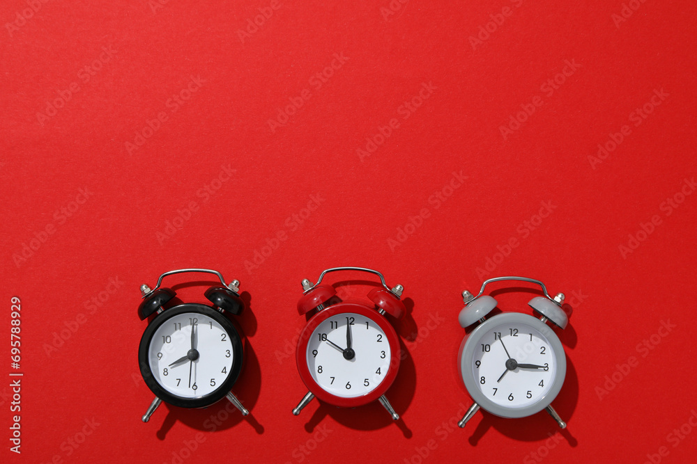 Classic multi-colored alarm clocks with on a red background Classic multi-colored alarm clocks with on a red background