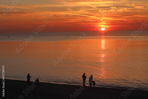 Sunrise on the Black Sea coast with silhouettes of people in Kobuleti, Georgia