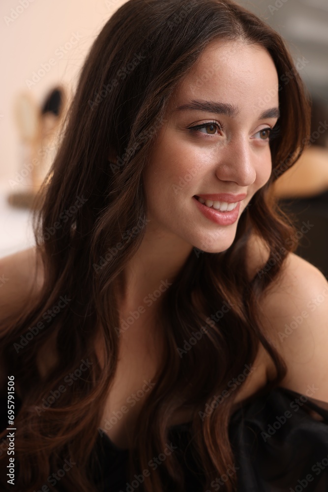 Portrait of smiling woman with curly hair on blurred background Portrait of smiling woman with curly hair on blurred background