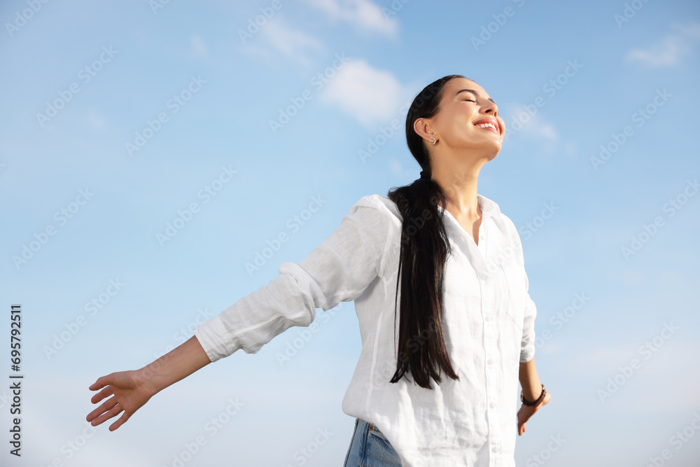 Feeling freedom. Happy woman with wide open arms against sky Feeling freedom. Happy woman with wide open arms against sky